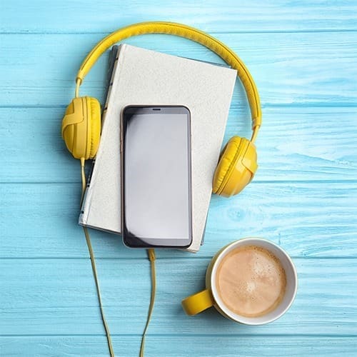 headphones and coffee for listening to archived education webinars